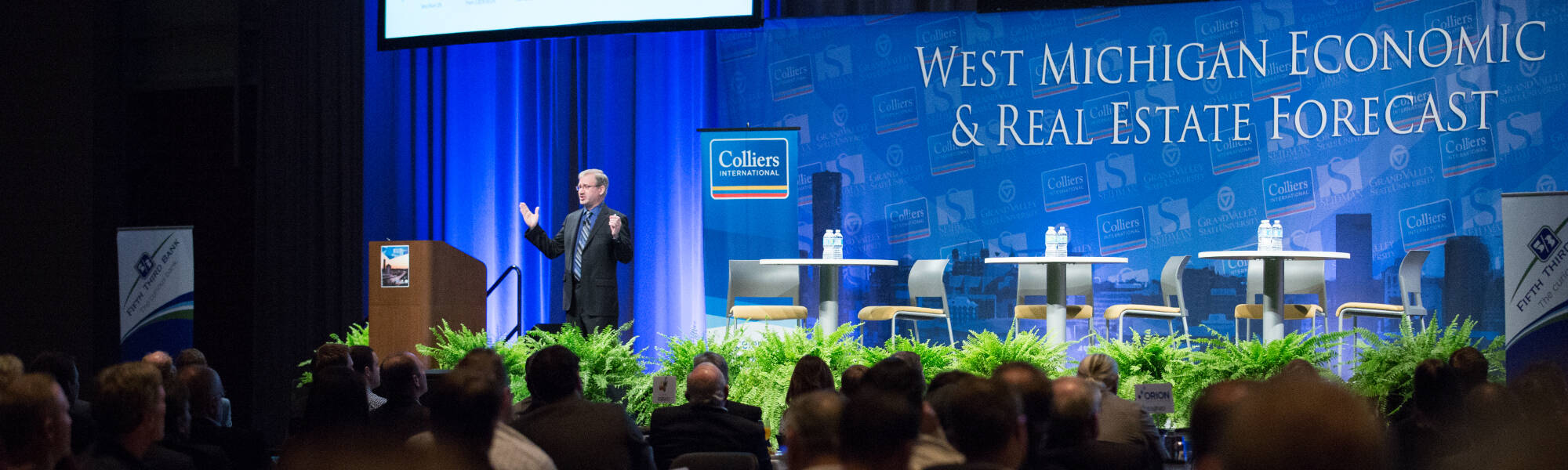 Dr. Paul Isely speaking in front of a crowd at the West Michigan Economic & Real Estate Forecast